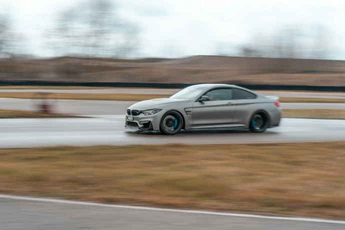 a silver car driving down a race track